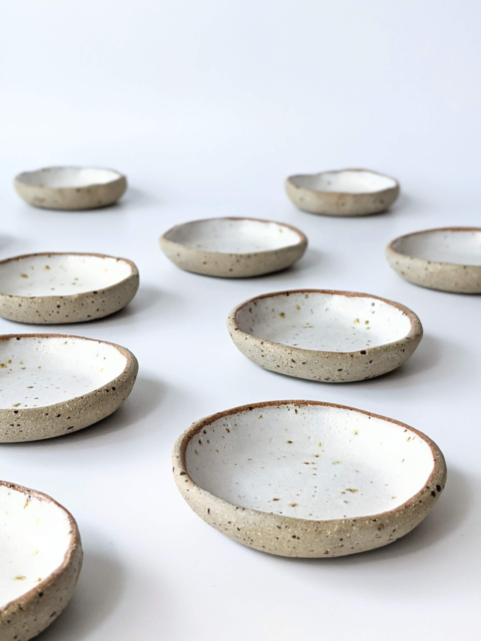Handmade speckled stoneware dishes with white glaze by Rouku Ceramics